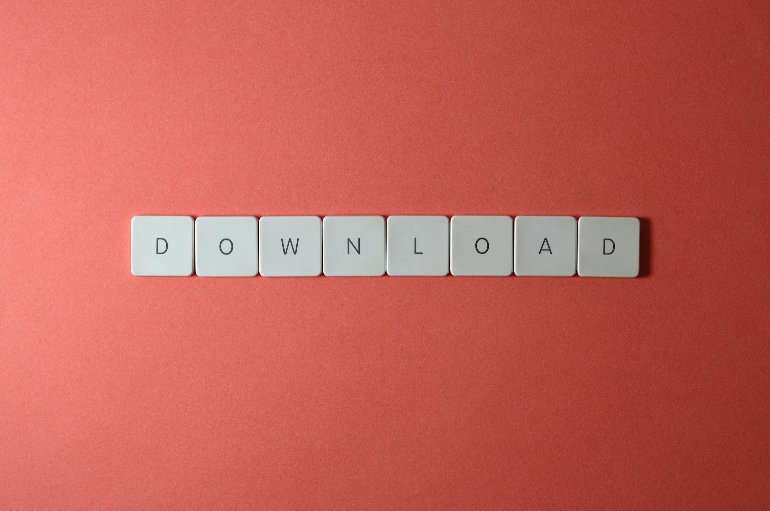 Minimalist photo of keyboard tiles spelling 'DOWNLOAD' on a red background.